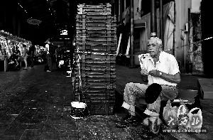 6月30日，在希腊首都雅典，一名老人坐在一个肉类市场入口处。新华/法新