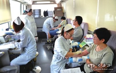 8月13日，在天津火车站广场的流动献血车上，医务人员在给旅客采血。新华社发